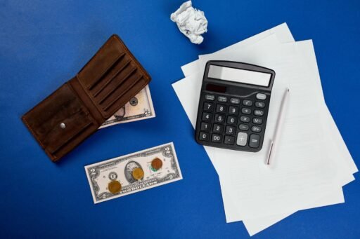 budget under 1000 dollars per month planning expenses with notebook and coins